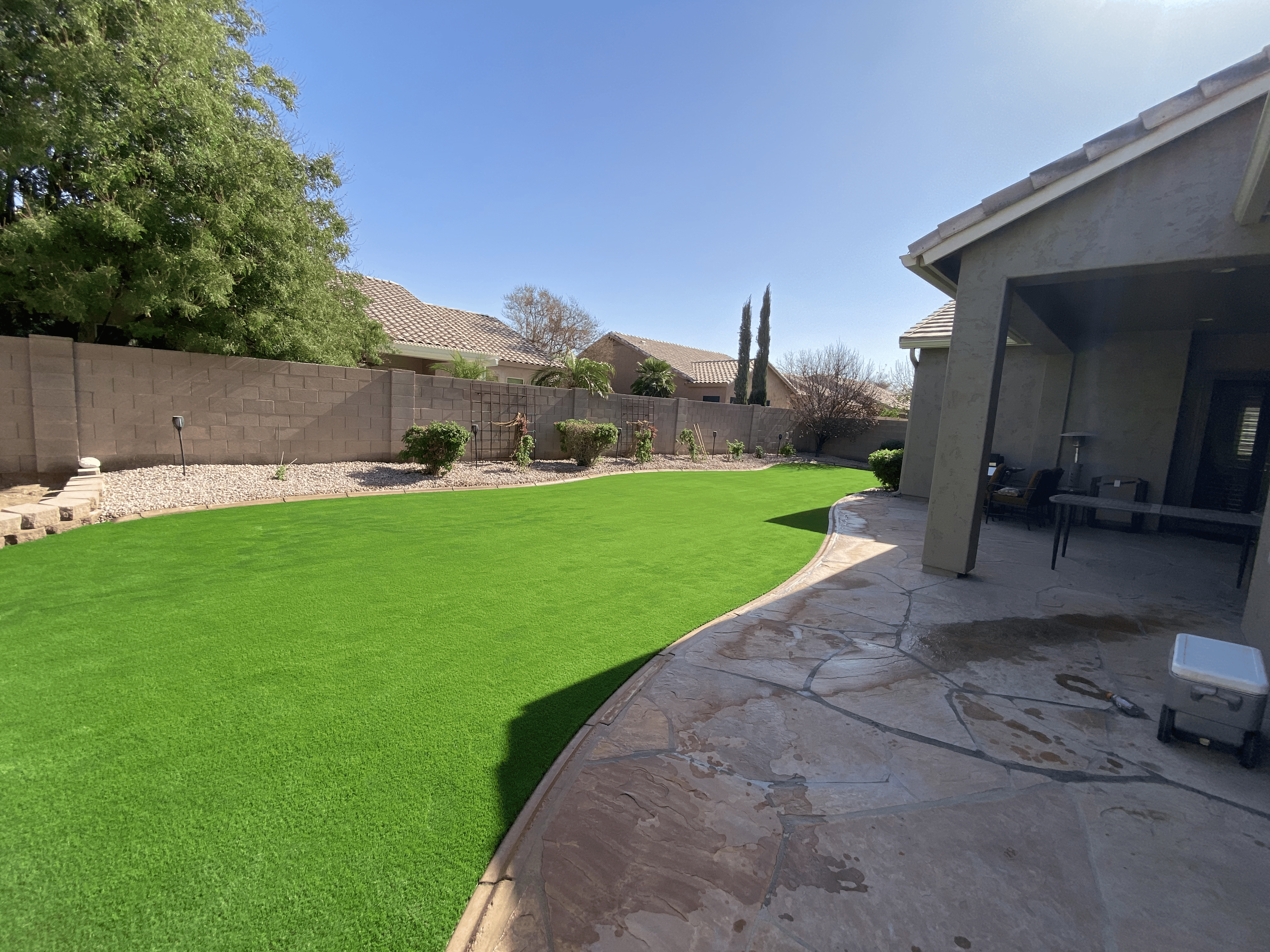 Finished backyard with artificial turf and flagstone patio — Bull Horn Landscaping